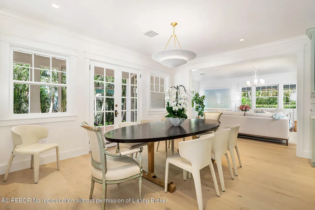 Elegant front view of the renovated $13.5M bungalow-style home at 142 Seabreeze Ave, Palm Beach, featuring guesthouse, heated pool, and lush landscaping