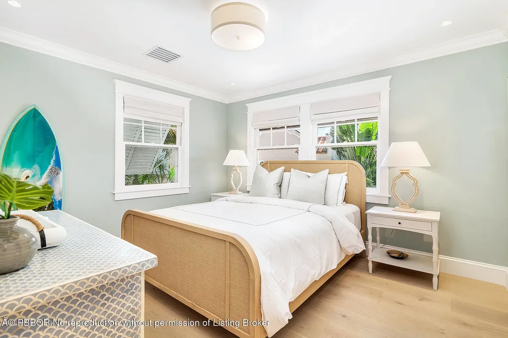 Elegant front view of the renovated $13.5M bungalow-style home at 142 Seabreeze Ave, Palm Beach, featuring guesthouse, heated pool, and lush landscaping