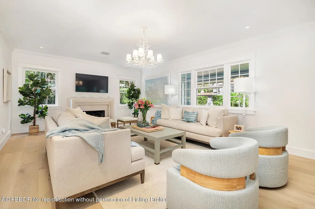 Elegant front view of the renovated $13.5M bungalow-style home at 142 Seabreeze Ave, Palm Beach, featuring guesthouse, heated pool, and lush landscaping