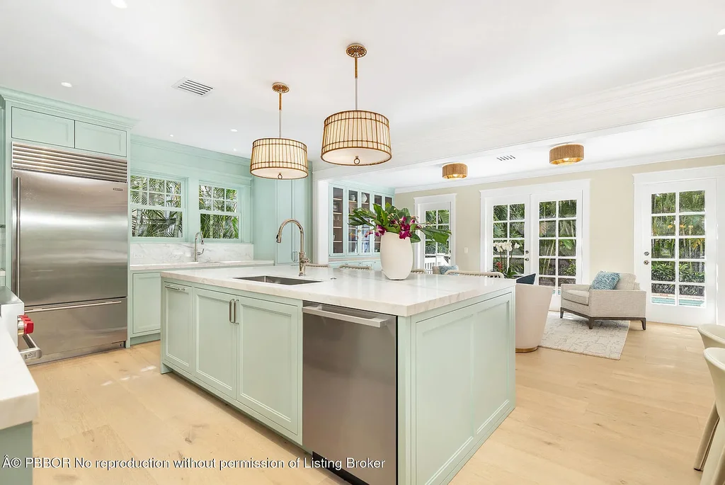 Elegant front view of the renovated $13.5M bungalow-style home at 142 Seabreeze Ave, Palm Beach, featuring guesthouse, heated pool, and lush landscaping