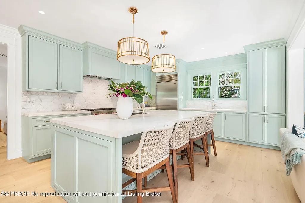 Elegant front view of the renovated $13.5M bungalow-style home at 142 Seabreeze Ave, Palm Beach, featuring guesthouse, heated pool, and lush landscaping