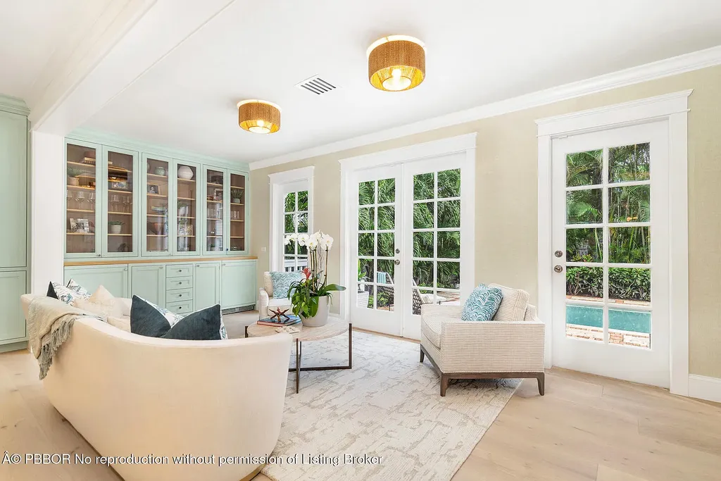 Elegant front view of the renovated $13.5M bungalow-style home at 142 Seabreeze Ave, Palm Beach, featuring guesthouse, heated pool, and lush landscaping
