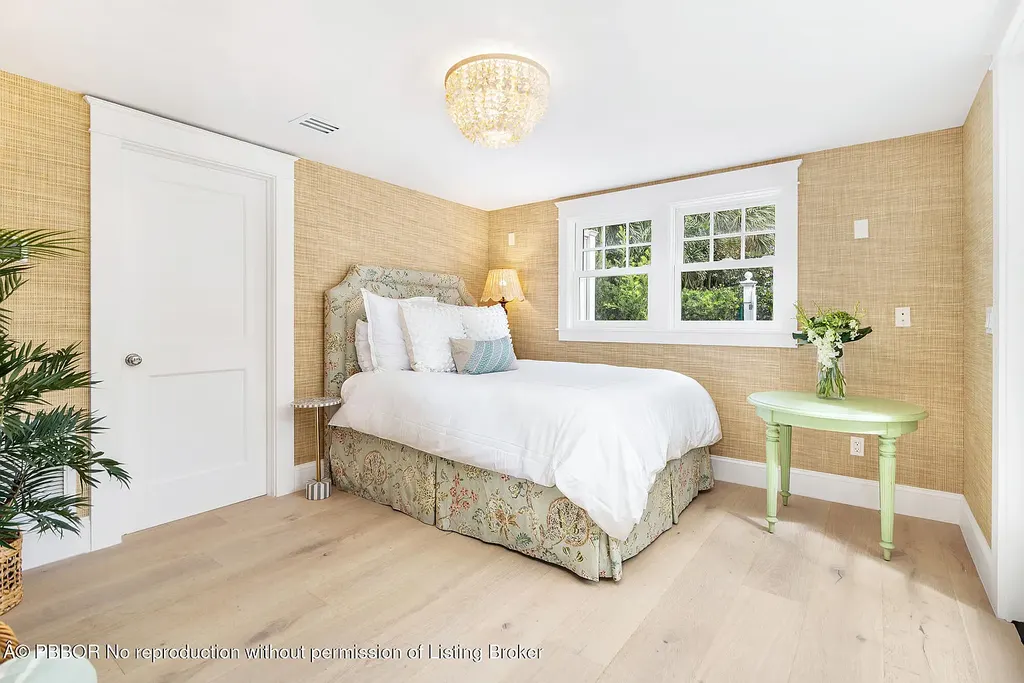 Elegant front view of the renovated $13.5M bungalow-style home at 142 Seabreeze Ave, Palm Beach, featuring guesthouse, heated pool, and lush landscaping