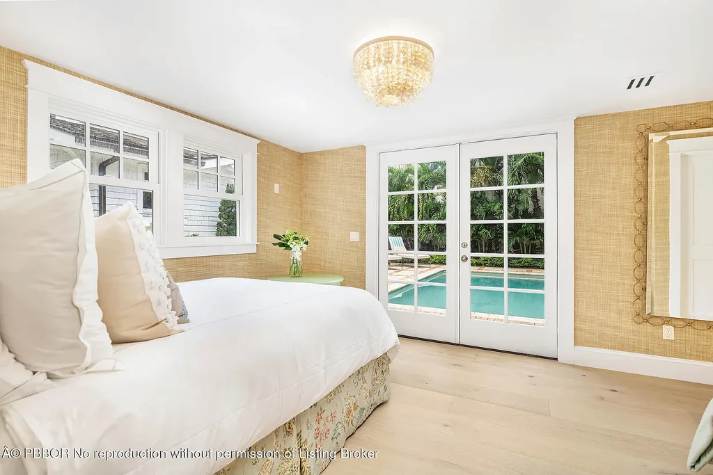 Elegant front view of the renovated $13.5M bungalow-style home at 142 Seabreeze Ave, Palm Beach, featuring guesthouse, heated pool, and lush landscaping