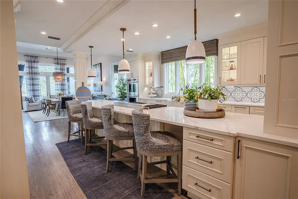Elegant Georgian colonial waterfront estate at 1541 Bay Point Dr in Sarasota, FL featuring private dock, saltwater pool, theater room, and lush tropical landscaping.