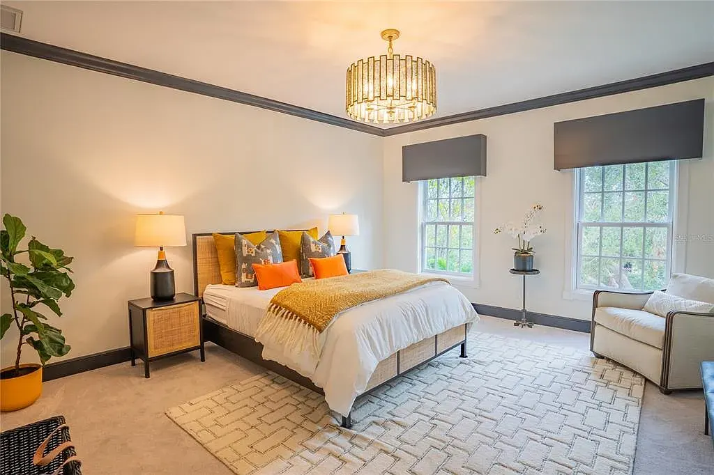Elegant Georgian colonial waterfront estate at 1541 Bay Point Dr in Sarasota, FL featuring private dock, saltwater pool, theater room, and lush tropical landscaping.