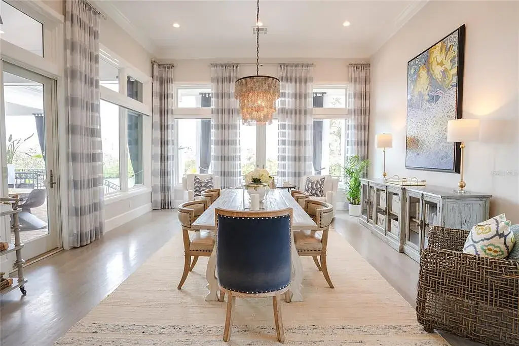 Elegant Georgian colonial waterfront estate at 1541 Bay Point Dr in Sarasota, FL featuring private dock, saltwater pool, theater room, and lush tropical landscaping.