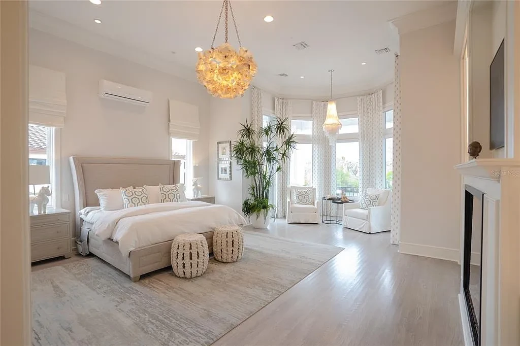Elegant Georgian colonial waterfront estate at 1541 Bay Point Dr in Sarasota, FL featuring private dock, saltwater pool, theater room, and lush tropical landscaping.