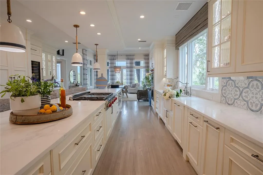 Elegant Georgian colonial waterfront estate at 1541 Bay Point Dr in Sarasota, FL featuring private dock, saltwater pool, theater room, and lush tropical landscaping.