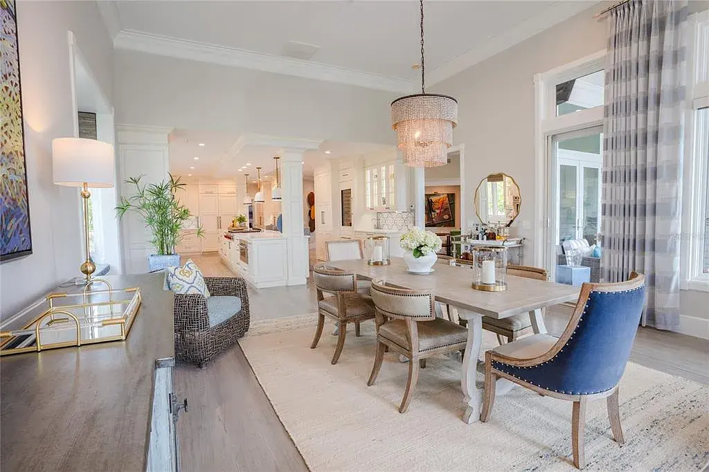 Elegant Georgian colonial waterfront estate at 1541 Bay Point Dr in Sarasota, FL featuring private dock, saltwater pool, theater room, and lush tropical landscaping.