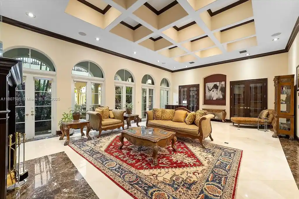 Front aerial view of 18451 SW 158th St luxury home in Miami featuring Mediterranean architecture, saltwater pool, private airstrip, and horse stables