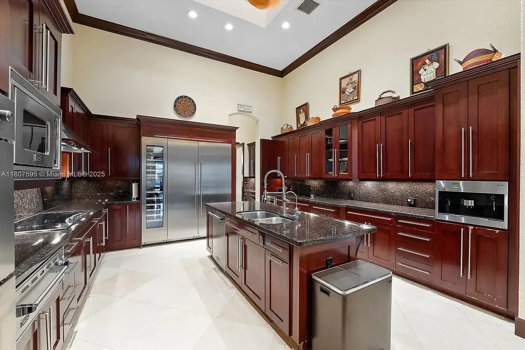Front aerial view of 18451 SW 158th St luxury home in Miami featuring Mediterranean architecture, saltwater pool, private airstrip, and horse stables
