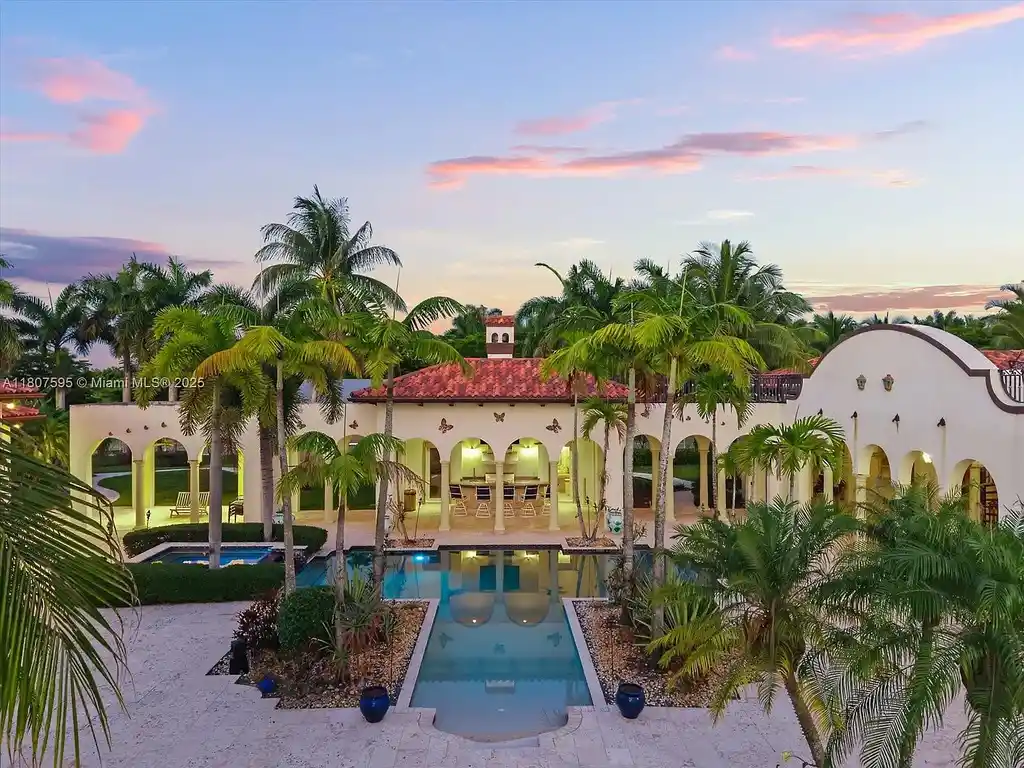 Front aerial view of 18451 SW 158th St luxury home in Miami featuring Mediterranean architecture, saltwater pool, private airstrip, and horse stables