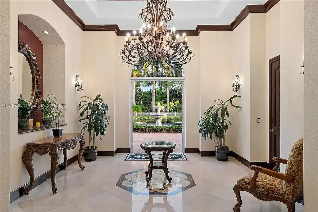Front aerial view of 18451 SW 158th St luxury home in Miami featuring Mediterranean architecture, saltwater pool, private airstrip, and horse stables