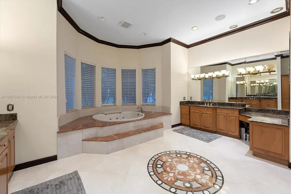 Front aerial view of 18451 SW 158th St luxury home in Miami featuring Mediterranean architecture, saltwater pool, private airstrip, and horse stables