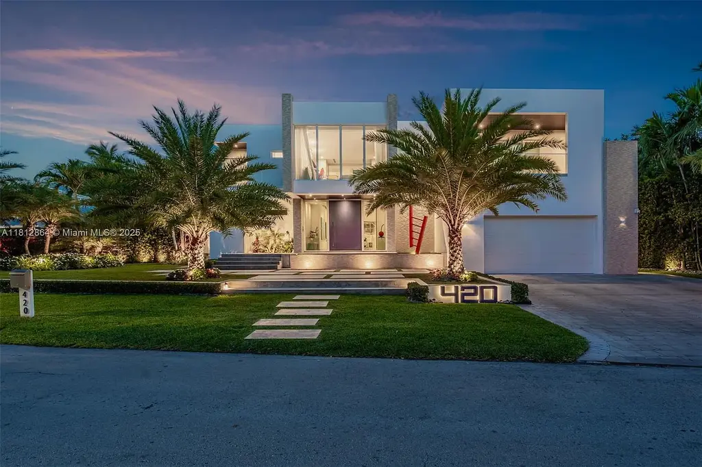 Modern waterfront home at 420 Island Dr in Key Biscayne with lush landscaping and canal view