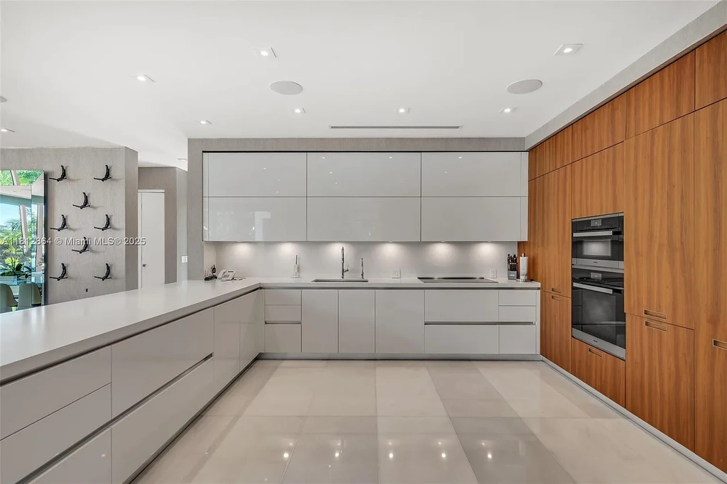 Modern waterfront home at 420 Island Dr in Key Biscayne with lush landscaping and canal view