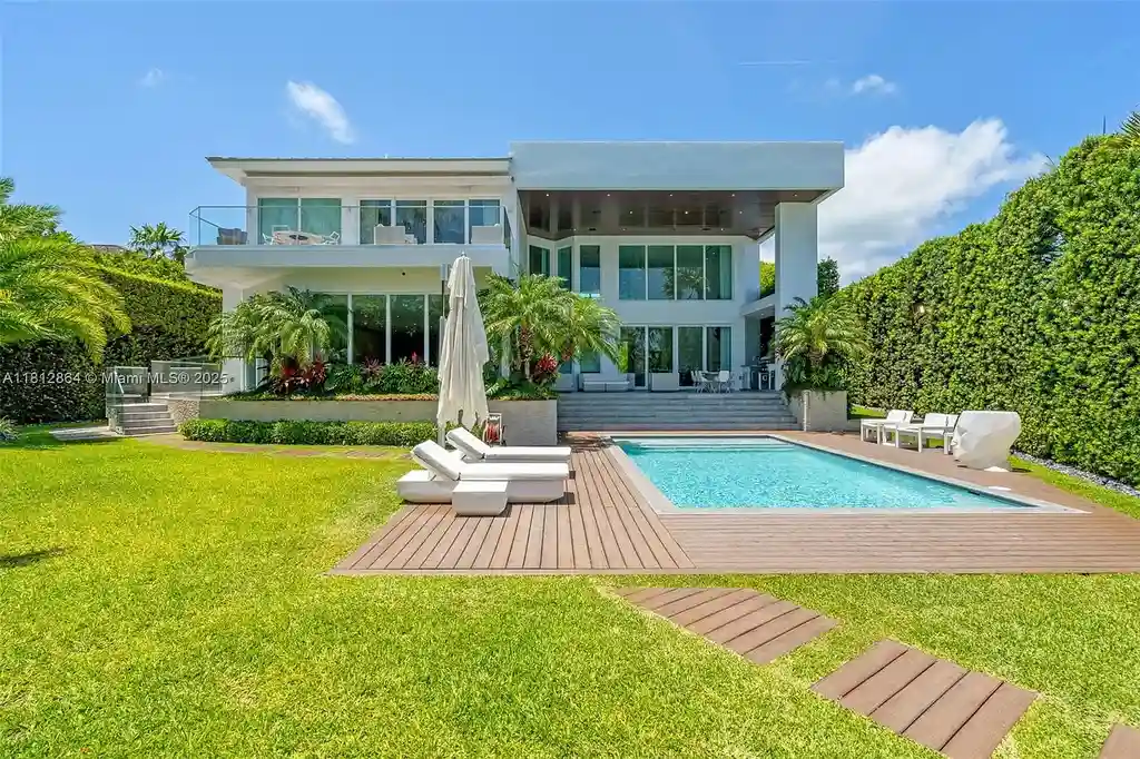 Modern waterfront home at 420 Island Dr in Key Biscayne with lush landscaping and canal view