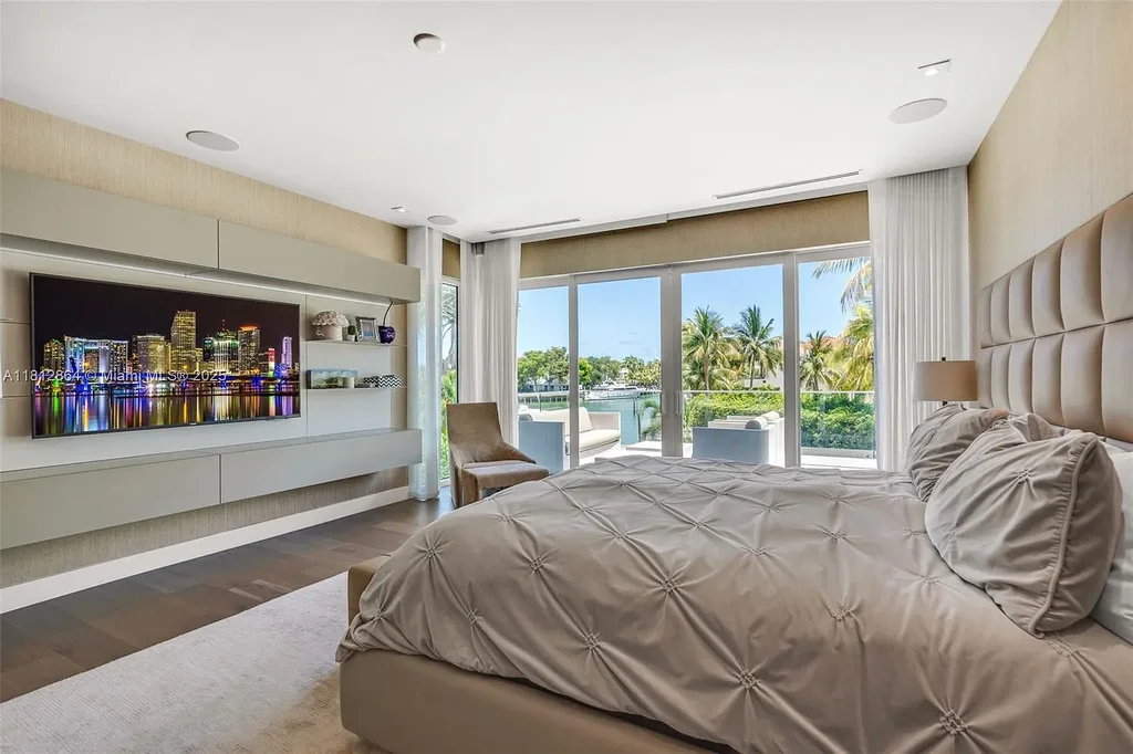 Modern waterfront home at 420 Island Dr in Key Biscayne with lush landscaping and canal view