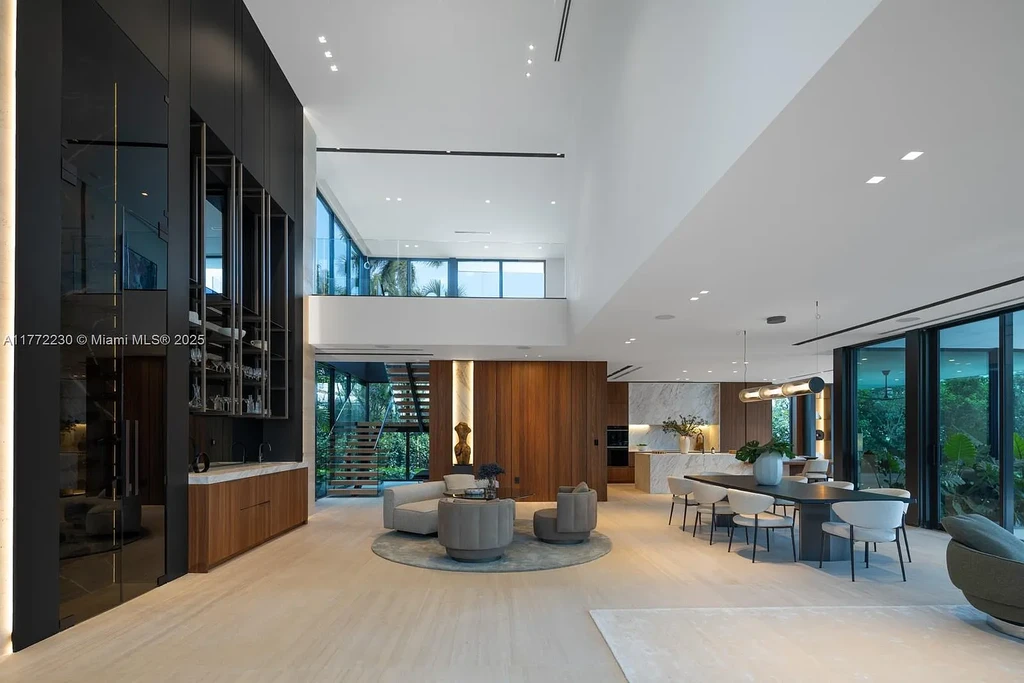Spacious living room featuring Minotti furnishings, floating staircase, and soaring ceilings in luxury Miami Beach home for sale