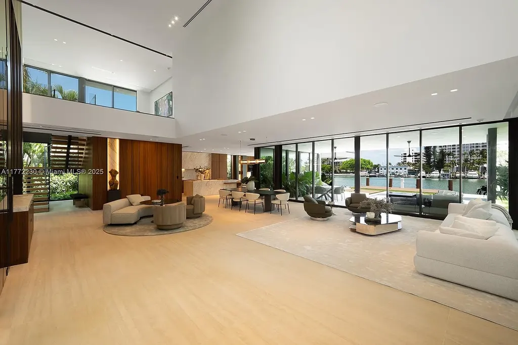 Spacious living room featuring Minotti furnishings, floating staircase, and soaring ceilings in luxury Miami Beach home for sale