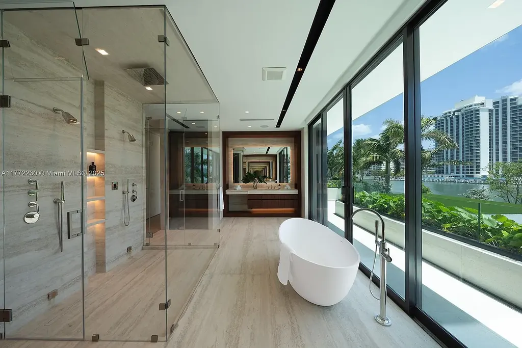 Spacious living room featuring Minotti furnishings, floating staircase, and soaring ceilings in luxury Miami Beach home for sale