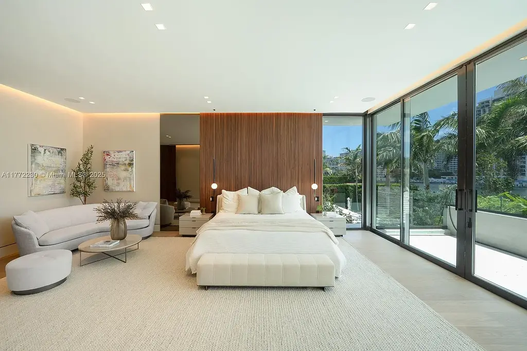 Spacious living room featuring Minotti furnishings, floating staircase, and soaring ceilings in luxury Miami Beach home for sale