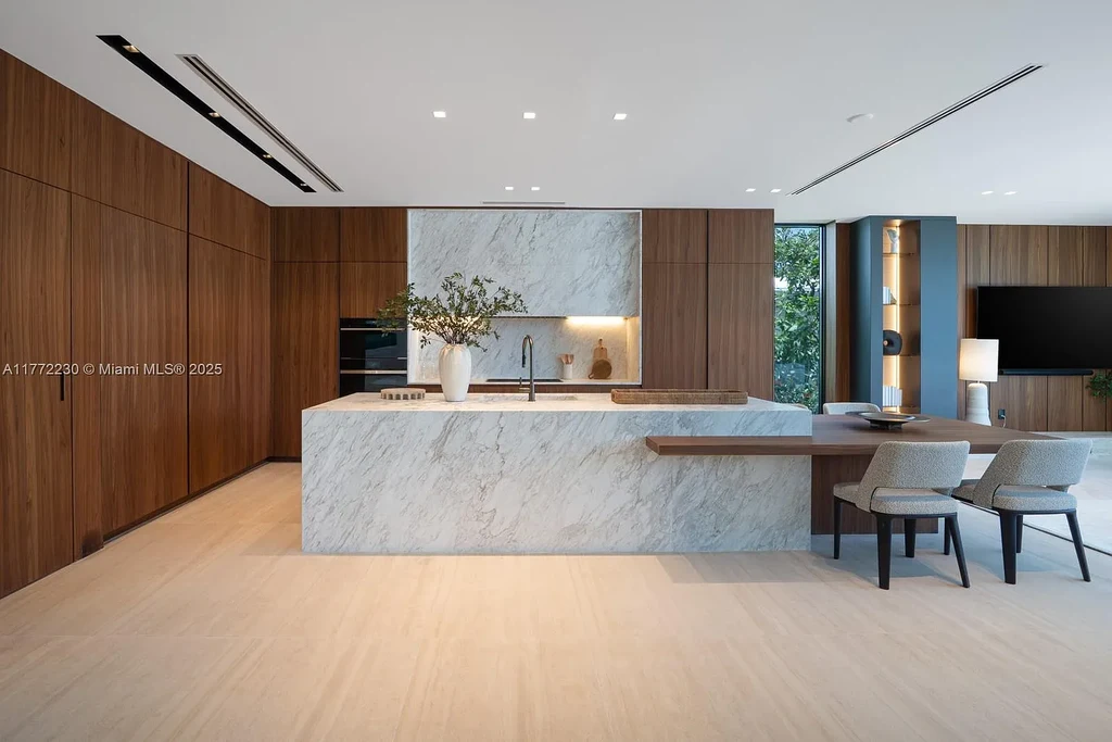 Spacious living room featuring Minotti furnishings, floating staircase, and soaring ceilings in luxury Miami Beach home for sale