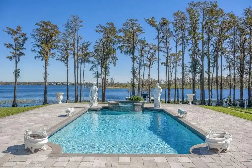 Lakefront luxury estate at 6139 Greatwater Dr in Windermere, featuring saltwater pool, summer kitchen, and panoramic views of Lake Tibet.