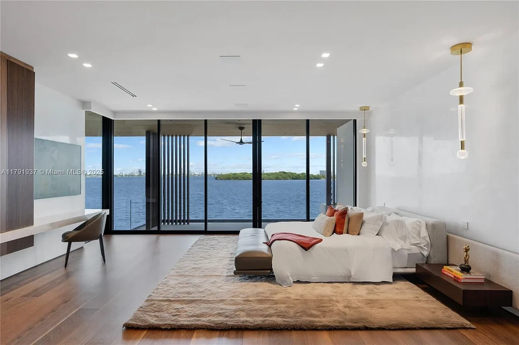 Exterior view of 11404 N Bayshore Dr, a $26.9M modern waterfront estate for sale in North Miami with bayfront dock, pool, and luxury tropical design.