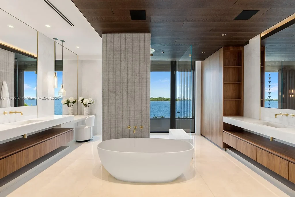 Exterior view of 11404 N Bayshore Dr, a $26.9M modern waterfront estate for sale in North Miami with bayfront dock, pool, and luxury tropical design.
