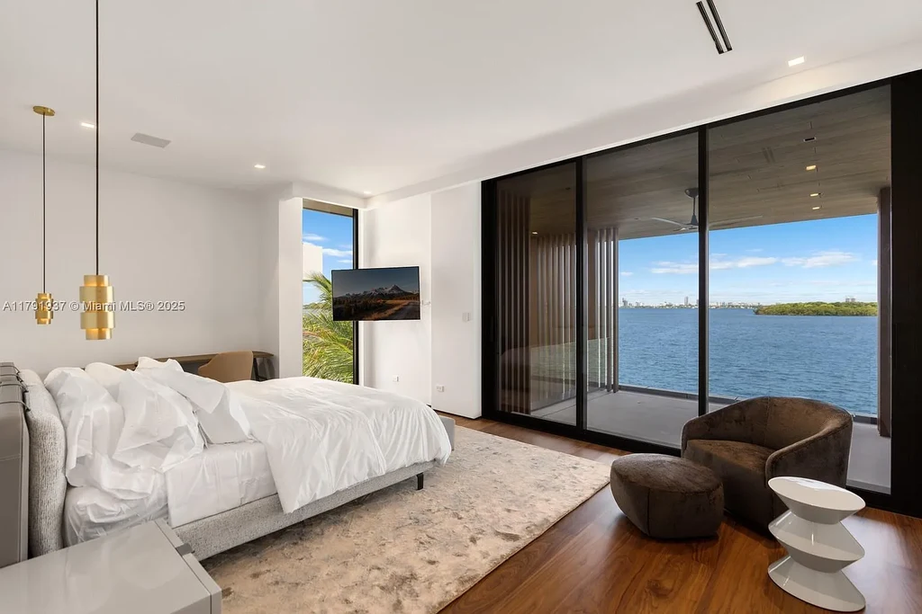 Exterior view of 11404 N Bayshore Dr, a $26.9M modern waterfront estate for sale in North Miami with bayfront dock, pool, and luxury tropical design.