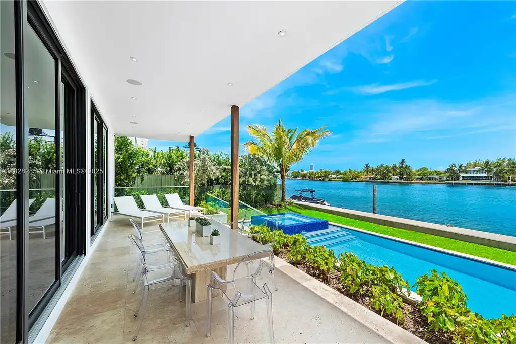 Modern waterfront home at 1410 S Biscayne Point Rd featuring limestone façade, private saltwater pool, and 75 feet of bay frontage in Miami Beach.