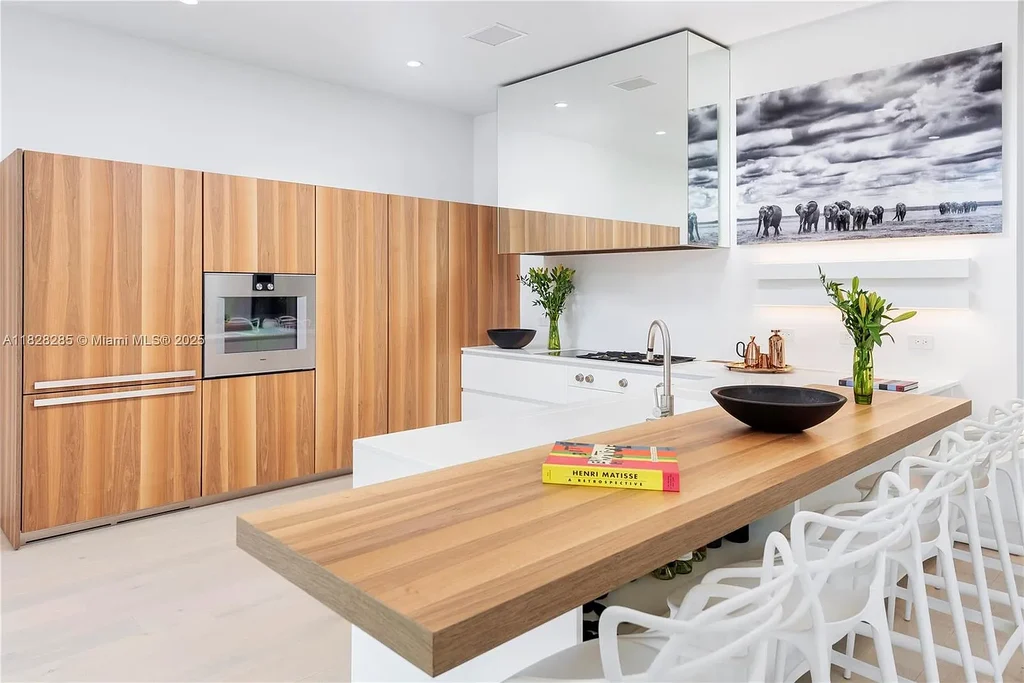 Modern waterfront home at 1410 S Biscayne Point Rd featuring limestone façade, private saltwater pool, and 75 feet of bay frontage in Miami Beach.