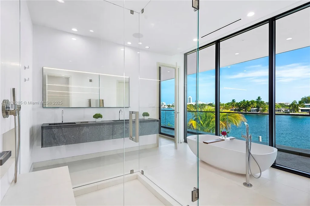 Modern waterfront home at 1410 S Biscayne Point Rd featuring limestone façade, private saltwater pool, and 75 feet of bay frontage in Miami Beach.