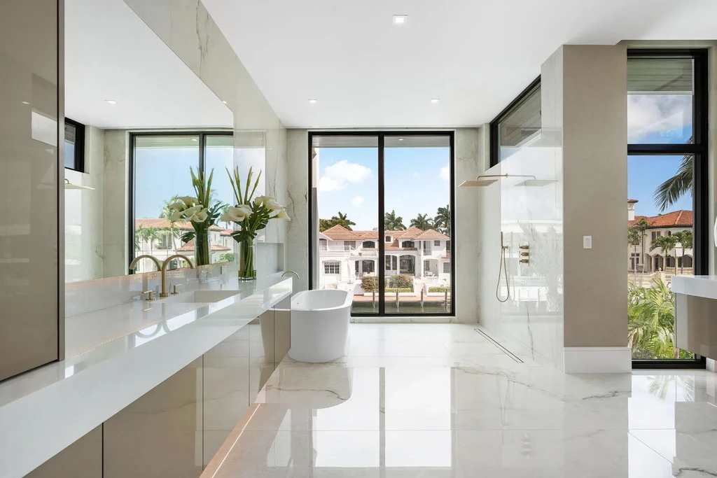 Exterior view of 169 W Coconut Palm Road, Boca Raton, featuring smart home design, resort-style pool, and canal frontage in Royal Palm Yacht & Country Club