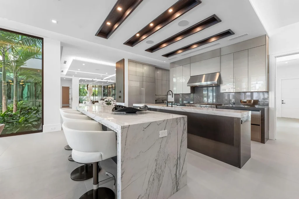 Exterior view of 169 W Coconut Palm Road, Boca Raton, featuring smart home design, resort-style pool, and canal frontage in Royal Palm Yacht & Country Club