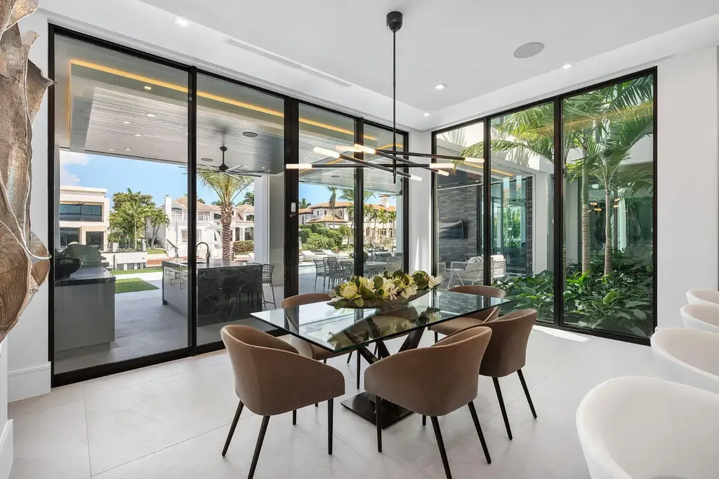 Exterior view of 169 W Coconut Palm Road, Boca Raton, featuring smart home design, resort-style pool, and canal frontage in Royal Palm Yacht & Country Club