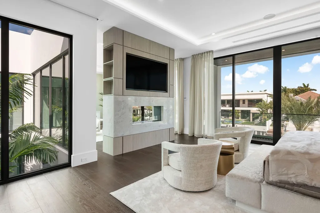 Exterior view of 169 W Coconut Palm Road, Boca Raton, featuring smart home design, resort-style pool, and canal frontage in Royal Palm Yacht & Country Club