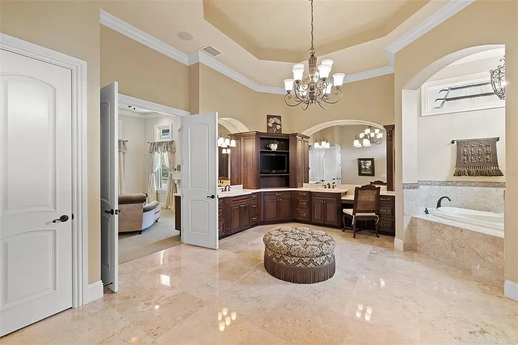 Lakefront luxury estate at 18521 Wayne Rd in Odessa FL featuring a resort-style saltwater pool, grand circular driveway, and manicured 4.75-acre grounds