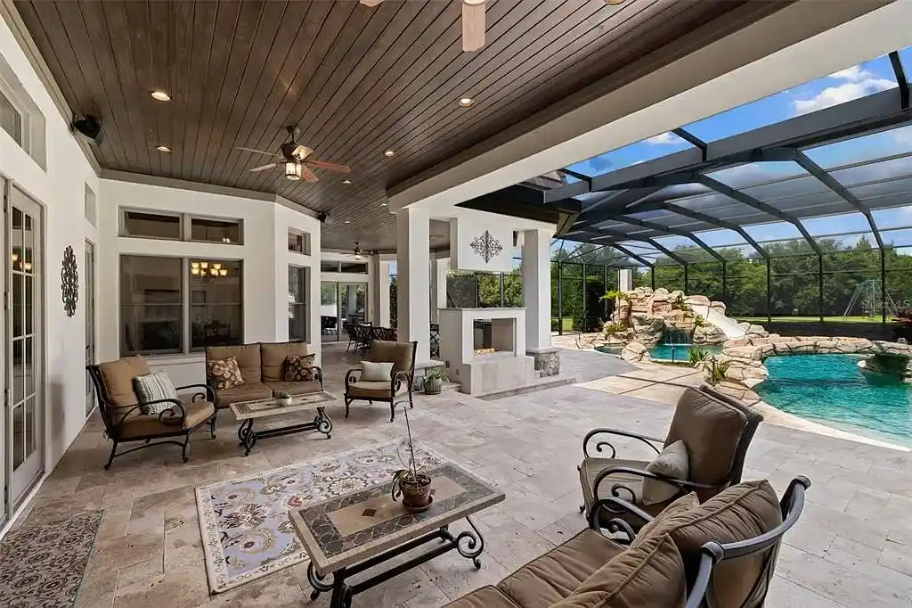Lakefront luxury estate at 18521 Wayne Rd in Odessa FL featuring a resort-style saltwater pool, grand circular driveway, and manicured 4.75-acre grounds