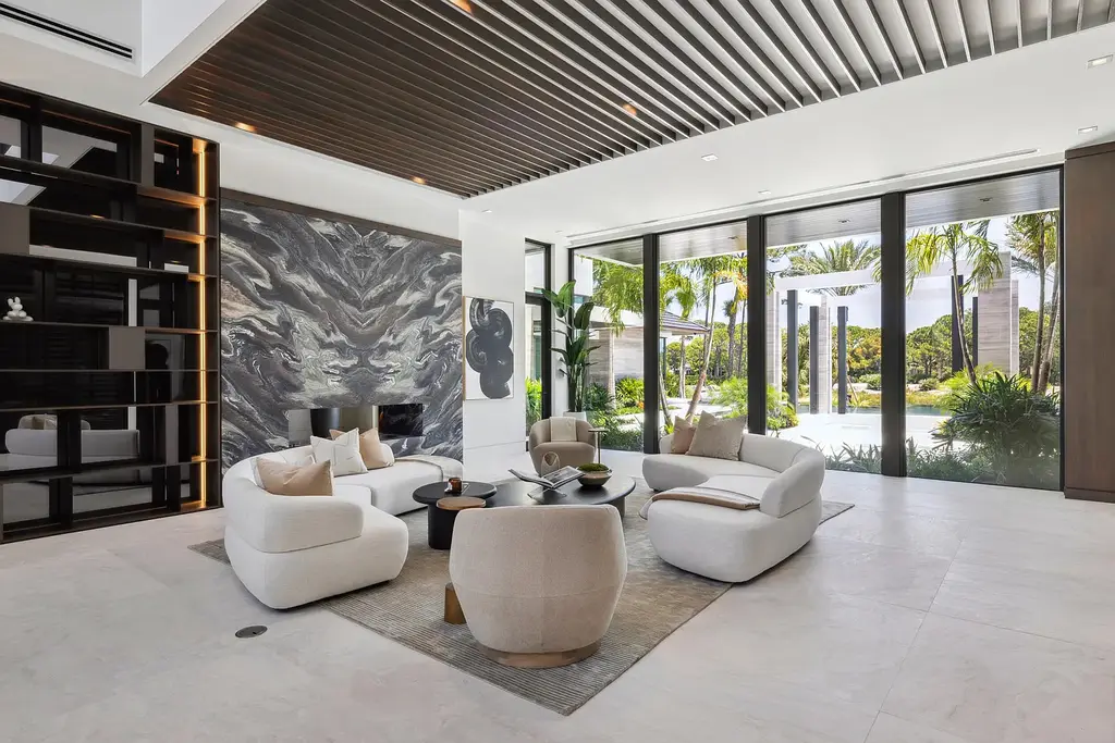 Front exterior of 228 Bears Club Drive luxury estate in Jupiter, Florida, featuring lakefront views, PebbleTec pool, and Mediterranean-inspired architecture