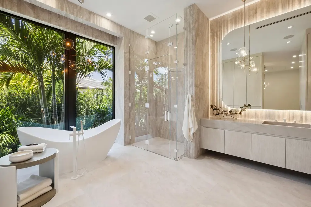 Front exterior of 228 Bears Club Drive luxury estate in Jupiter, Florida, featuring lakefront views, PebbleTec pool, and Mediterranean-inspired architecture