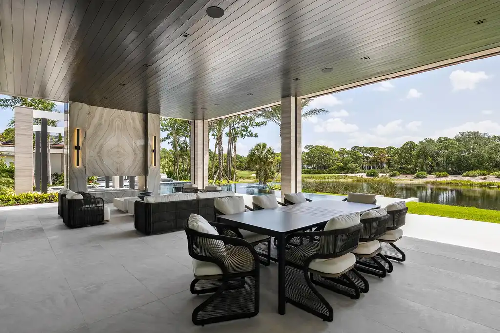 Front exterior of 228 Bears Club Drive luxury estate in Jupiter, Florida, featuring lakefront views, PebbleTec pool, and Mediterranean-inspired architecture