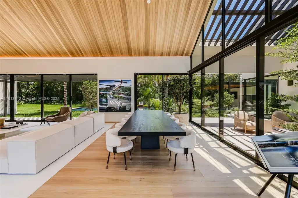 Exterior view of 4820 SW 86th Ter showcasing SAOTA's modern architecture with floor-to-ceiling glass and tropical landscaping.