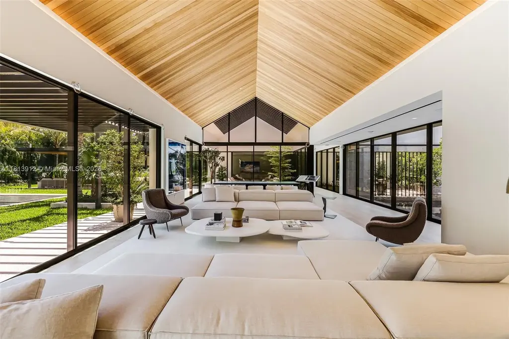 Exterior view of 4820 SW 86th Ter showcasing SAOTA's modern architecture with floor-to-ceiling glass and tropical landscaping.