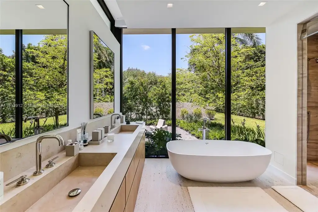 Exterior view of 4820 SW 86th Ter showcasing SAOTA's modern architecture with floor-to-ceiling glass and tropical landscaping.