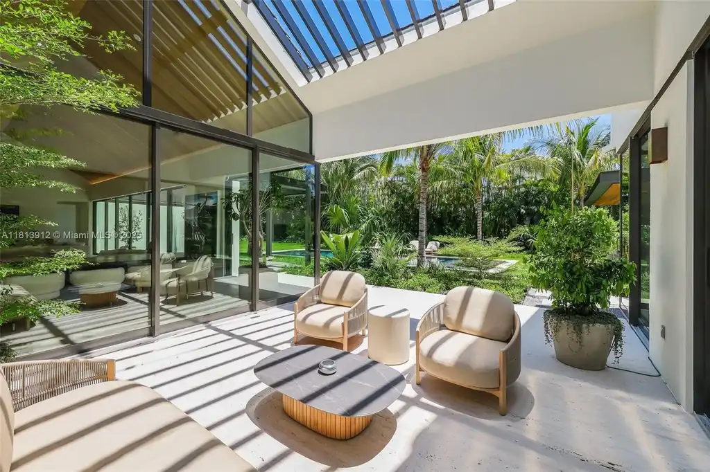 Exterior view of 4820 SW 86th Ter showcasing SAOTA's modern architecture with floor-to-ceiling glass and tropical landscaping.