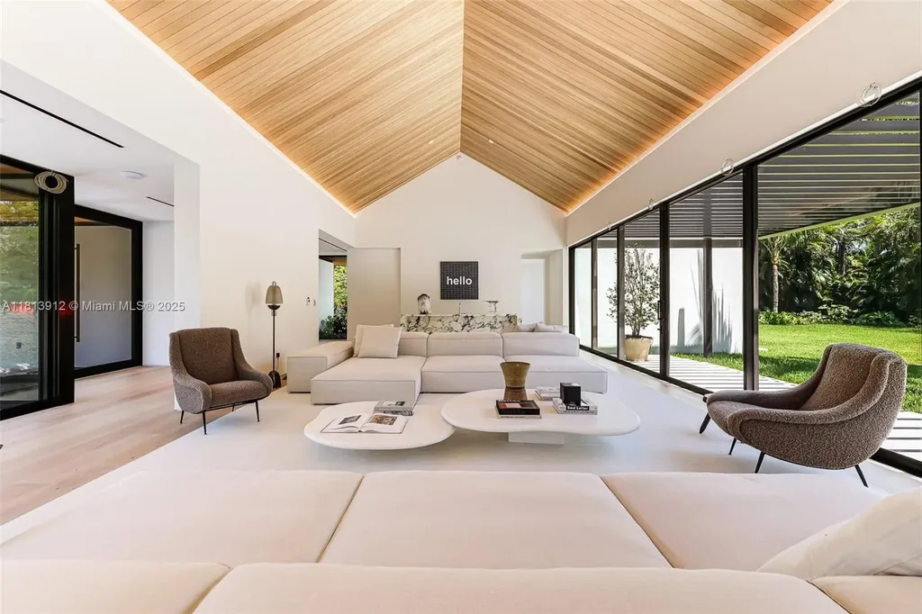 Exterior view of 4820 SW 86th Ter showcasing SAOTA's modern architecture with floor-to-ceiling glass and tropical landscaping.