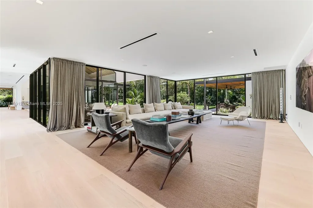 Exterior view of 4820 SW 86th Ter showcasing SAOTA's modern architecture with floor-to-ceiling glass and tropical landscaping.